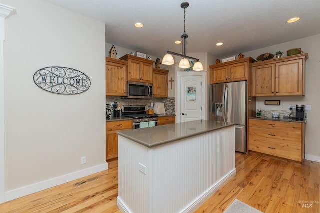 818 W Dallan Woods Way, Nampa, ID 83686 - kitchen with stainless steel appliances, backsplash, light wood-style floors, dark countertops, and recessed lighting