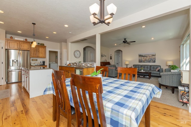 818 W Dallan Woods Way, Nampa, ID 83686 - dining room with washer / dryer, arched walkways, light wood-style flooring, recessed lighting, and a chandelier