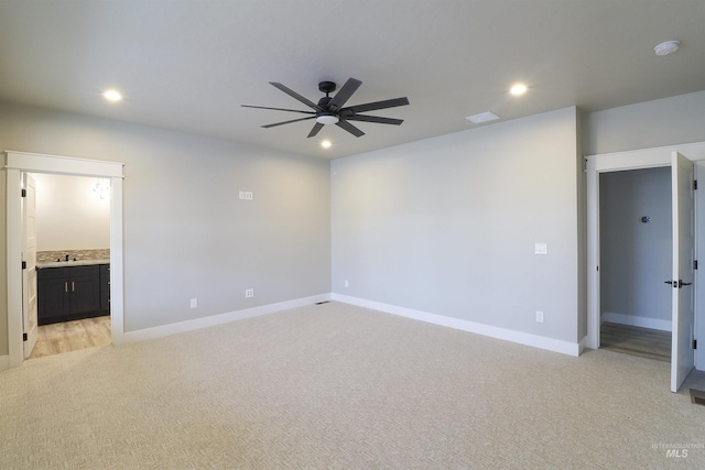 interior space with ceiling fan, light colored carpet, and sink