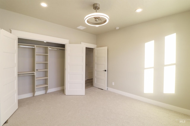 unfurnished bedroom featuring light colored carpet and a closet