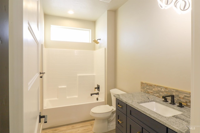 full bathroom featuring toilet,  shower combination, vanity, hardwood / wood-style flooring, and backsplash