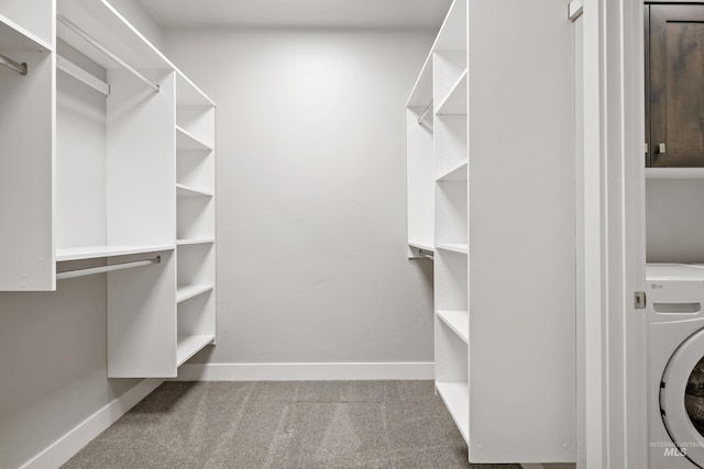 walk in closet with washer / clothes dryer and carpet floors