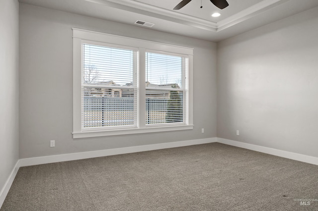 carpeted empty room featuring ceiling fan and a tray ceiling