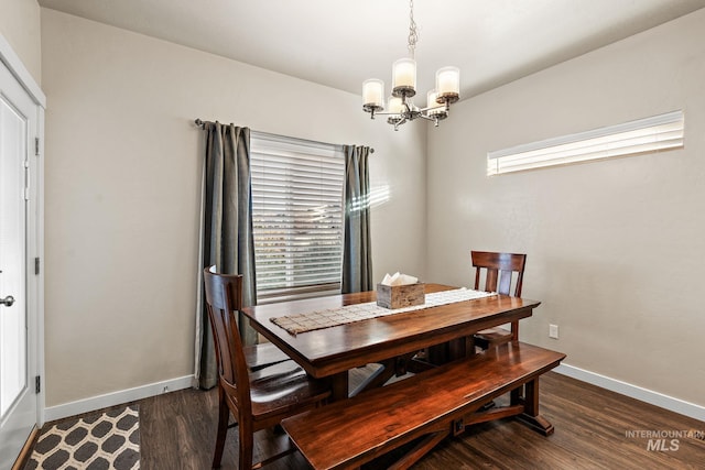 dining room featuring dark wood-type flooring, a notable chandelier, and plenty of natural light