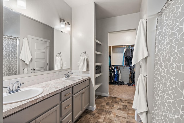 bathroom featuring vanity, built in features, and tasteful backsplash