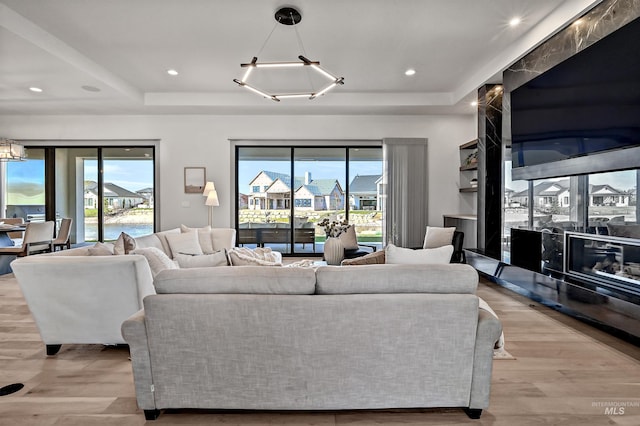 1771 S Riparian Way, Eagle, ID 83616 - living room featuring a chandelier, light wood-style flooring, a tray ceiling, healthy amount of natural light, and recessed lighting