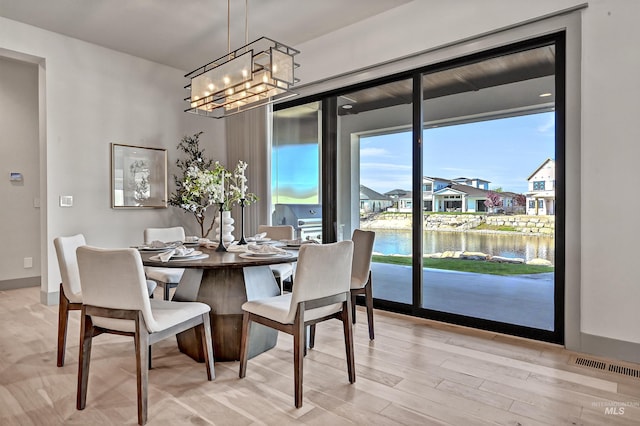 1771 S Riparian Way, Eagle, ID 83616 - dining area featuring a chandelier, light wood finished floors, a water view, and a residential view