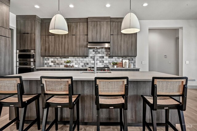1771 S Riparian Way, Eagle, ID 83616 - kitchen with modern cabinets, light countertops, double oven, decorative backsplash, and recessed lighting
