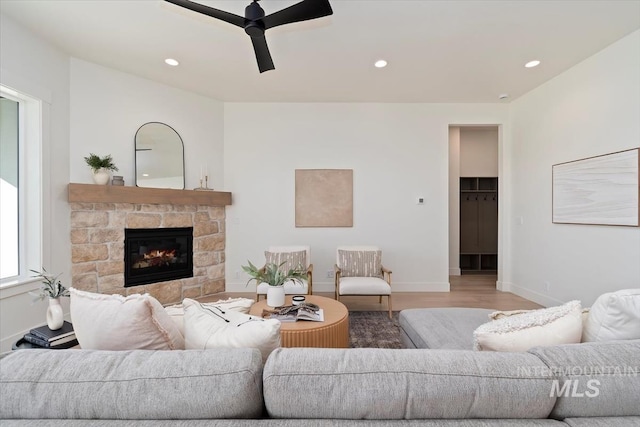 living area featuring light wood finished floors, ceiling fan, a fireplace, and recessed lighting