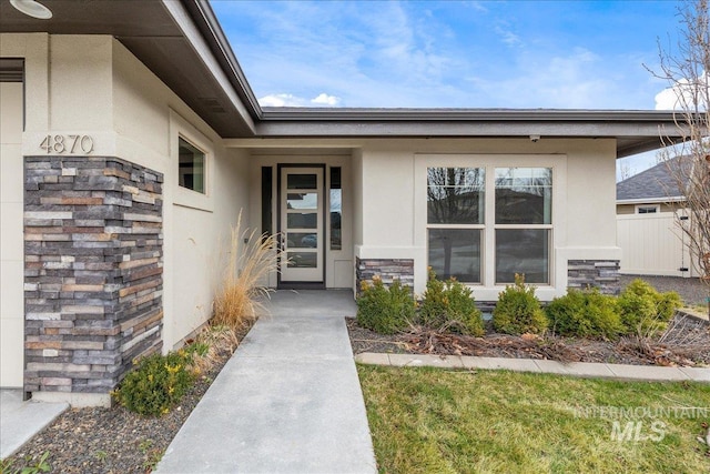 entrance to property with stone siding and stucco siding
