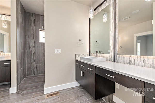 bathroom featuring wood finish floors, vanity, and walk in shower