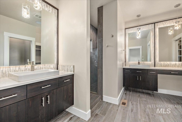 full bath featuring wood tiled floor, two vanities, and a sink