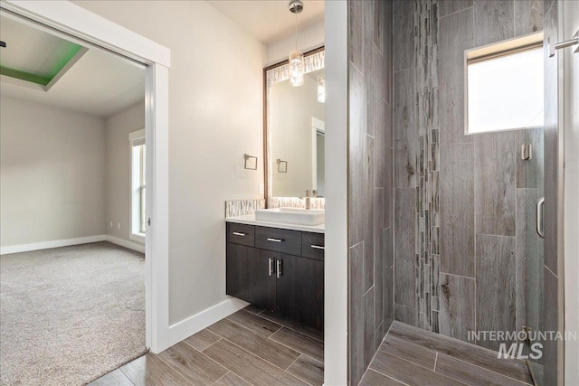 full bathroom with a shower stall, vanity, baseboards, and wood tiled floor