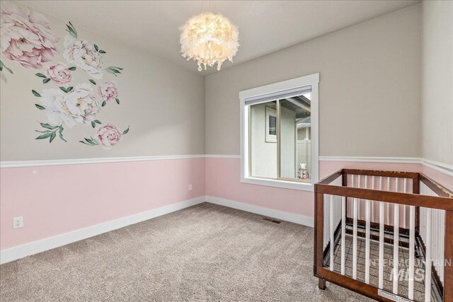 bedroom with an inviting chandelier, carpet, visible vents, and baseboards