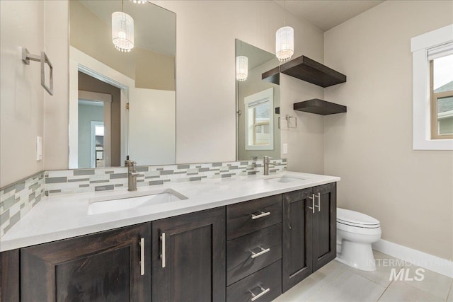 full bathroom featuring double vanity, toilet, tasteful backsplash, and a sink