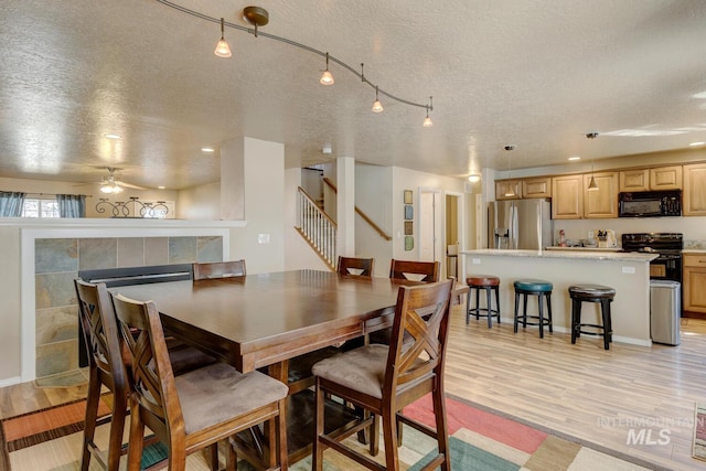 1587 N Firebrick Dr, Kuna, ID 83634 - dining area with light wood-type flooring, stairs, and a textured ceiling