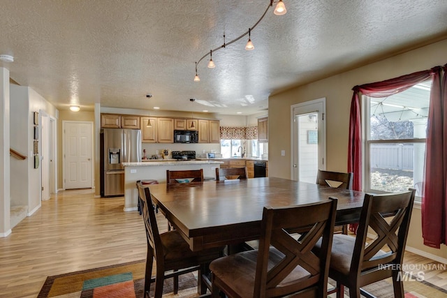 1587 N Firebrick Dr, Kuna, ID 83634 - dining space featuring baseboards, a textured ceiling, and light wood-style floors
