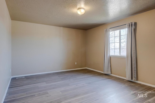 1587 N Firebrick Dr, Kuna, ID 83634 - spare room with a textured ceiling, baseboards, and wood finished floors