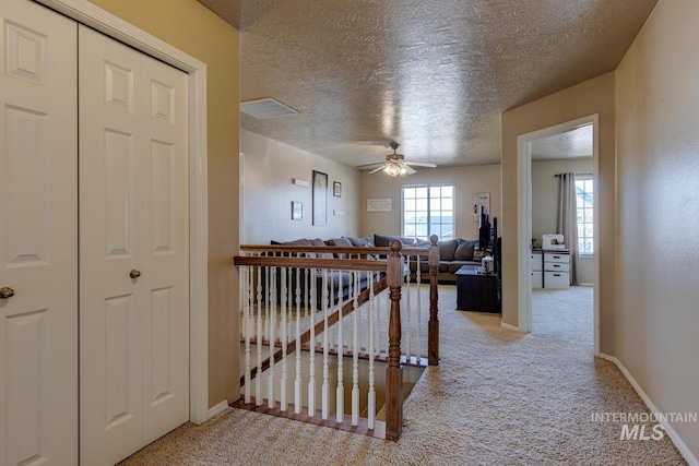 1587 N Firebrick Dr, Kuna, ID 83634 - corridor with carpet, visible vents, a textured ceiling, an upstairs landing, and baseboards