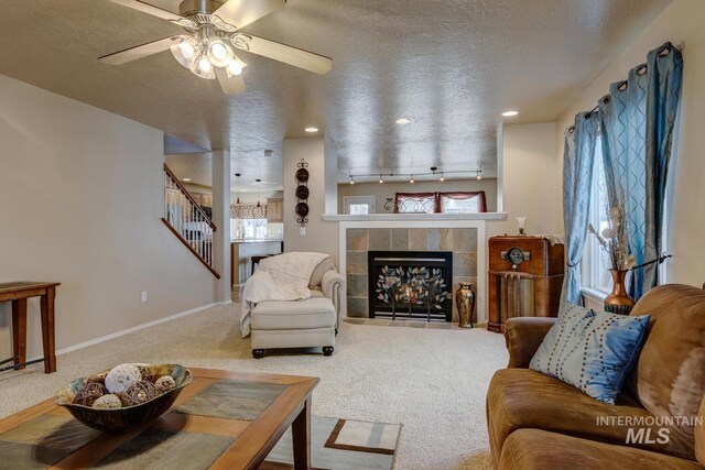 1587 N Firebrick Dr, Kuna, ID 83634 - living room featuring a textured ceiling, stairway, carpet, and a tile fireplace