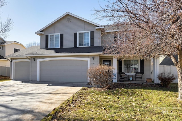 1587 N Firebrick Dr, Kuna, ID 83634 - traditional-style house featuring driveway, an attached garage, covered porch, fence, and a front lawn