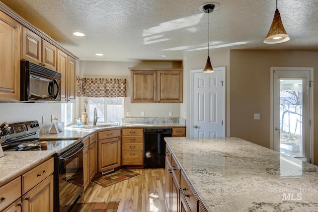 1587 N Firebrick Dr, Kuna, ID 83634 - kitchen featuring light wood-style floors, hanging light fixtures, light stone countertops, black appliances, and a sink