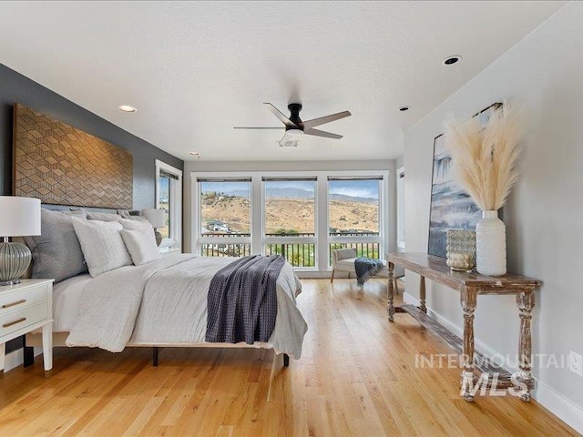 bedroom with ceiling fan, light hardwood / wood-style flooring, and access to exterior