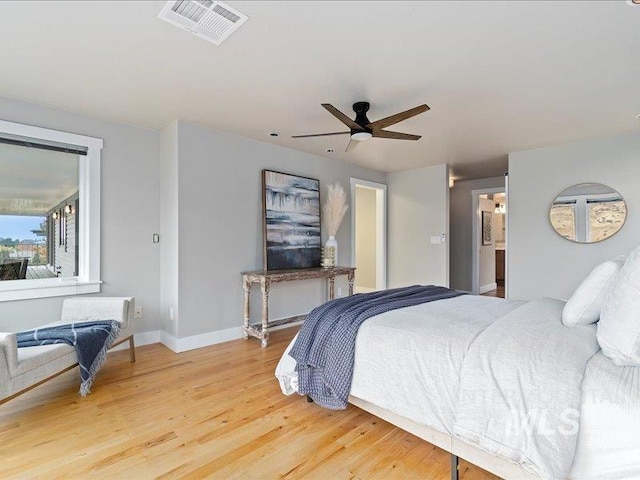 bedroom featuring light wood finished floors, baseboards, a ceiling fan, and visible vents