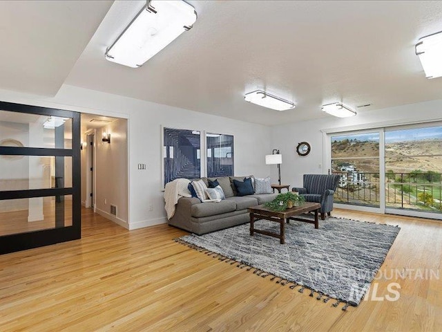 living room with baseboards and wood finished floors