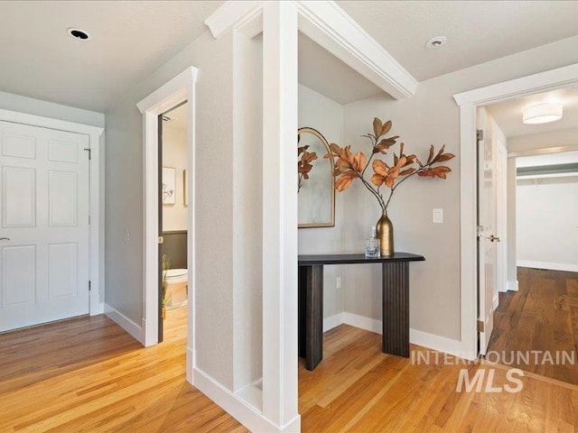 hallway featuring baseboards and light wood finished floors