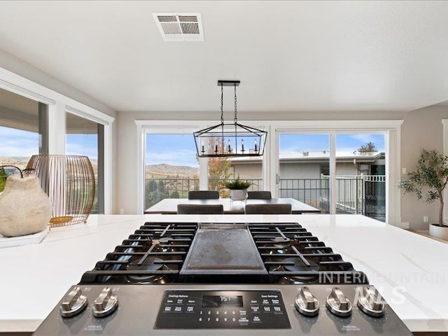 kitchen with a wealth of natural light, stainless steel range, a mountain view, and decorative light fixtures