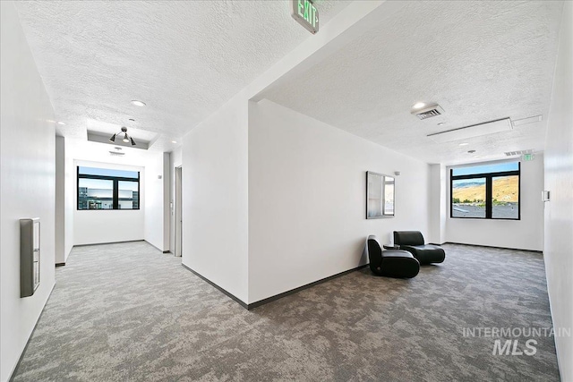 corridor with a textured ceiling and carpet