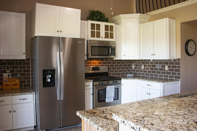 2722 Pascoe Ln, Nampa, ID 83686 - kitchen featuring stainless steel appliances, light stone countertops, tasteful backsplash, glass insert cabinets, and white cabinets