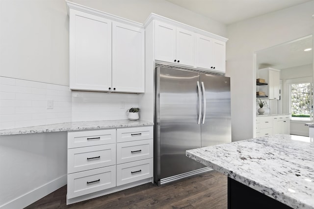 1910 W Campo Ln, Eagle, ID 83616 - kitchen featuring stainless steel refrigerator, white cabinets, light stone countertops, decorative backsplash, and dark wood-style flooring