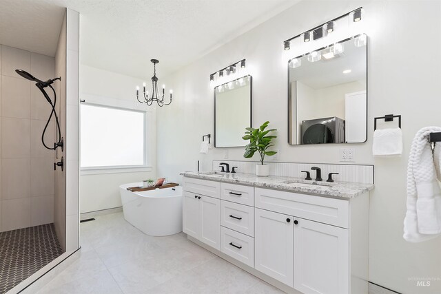 1910 W Campo Ln, Eagle, ID 83616 - bathroom with a chandelier, tiled shower, a freestanding tub, double vanity, and tile patterned flooring