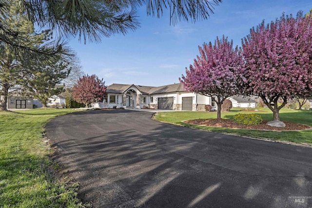 1910 W Campo Ln, Eagle, ID 83616 - view of front of home featuring an attached garage, driveway, a front lawn, and an outbuilding