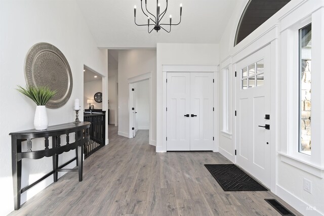 1910 W Campo Ln, Eagle, ID 83616 - foyer entrance featuring vaulted ceiling, a chandelier, wood finished floors, and baseboards