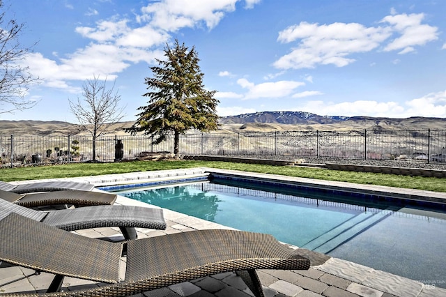 view of swimming pool featuring a fenced in pool, a fenced backyard, and a mountain view