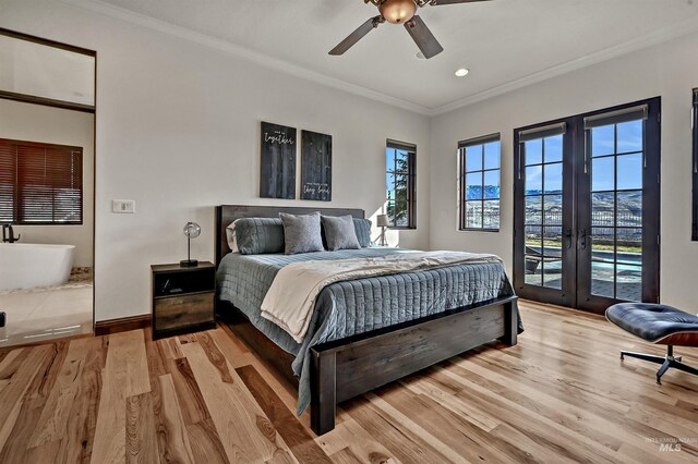 bedroom with crown molding, light wood-type flooring, french doors, and access to outside