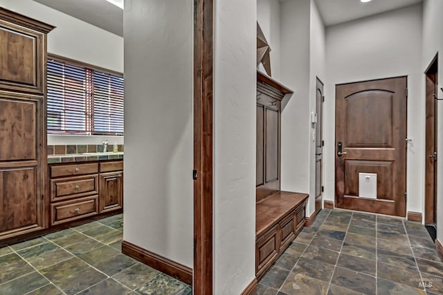 interior space featuring stone finish floor and baseboards