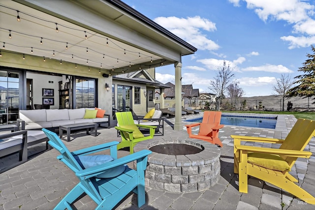 view of patio with a fenced in pool, an outdoor living space with a fire pit, and fence