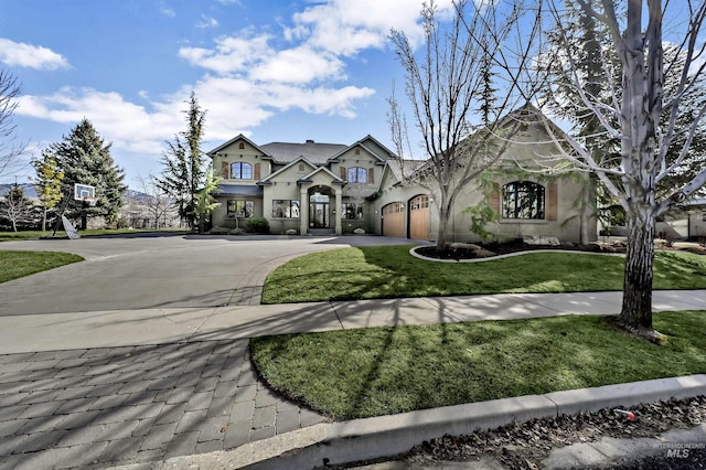 view of front of house with stucco siding, an attached garage, concrete driveway, and a front lawn