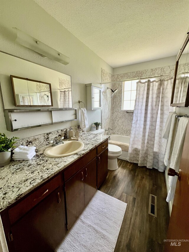 2025 10th Ave, Clarkston, WA 99403 - full bath with toilet, wood finished floors, shower / bath combo, a textured ceiling, and visible vents