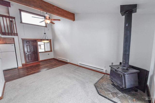 1607 Davis Ave Unit C2, Mccall, ID 83638 - unfurnished living room featuring a baseboard heating unit, dark carpet, a wood stove, and a ceiling fan