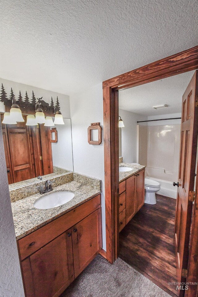 1607 Davis Ave Unit C2, Mccall, ID 83638 - bathroom featuring a textured ceiling, two vanities, toilet, and shower / bath combination