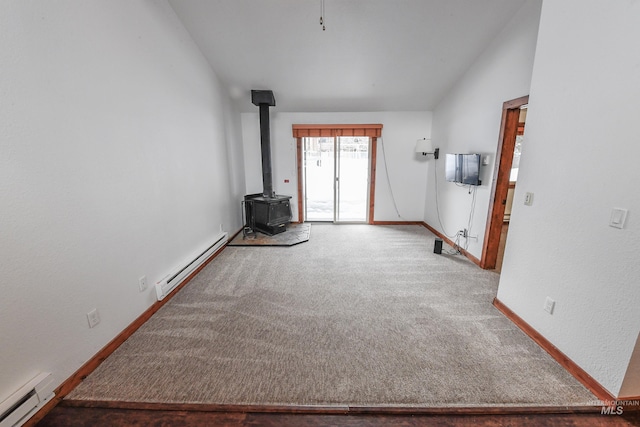 1607 Davis Ave Unit C2, Mccall, ID 83638 - unfurnished living room with a baseboard radiator, a wood stove, carpet floors, baseboards, and vaulted ceiling