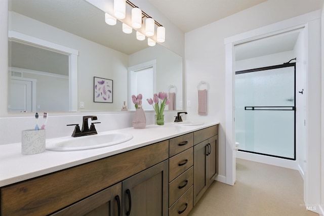 bathroom featuring double vanity, a stall shower, toilet, and a sink