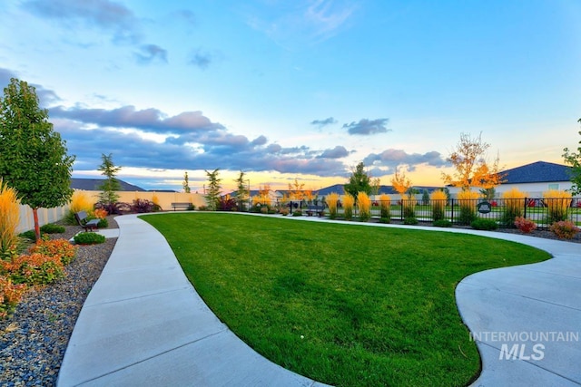 view of property's community featuring a yard and fence