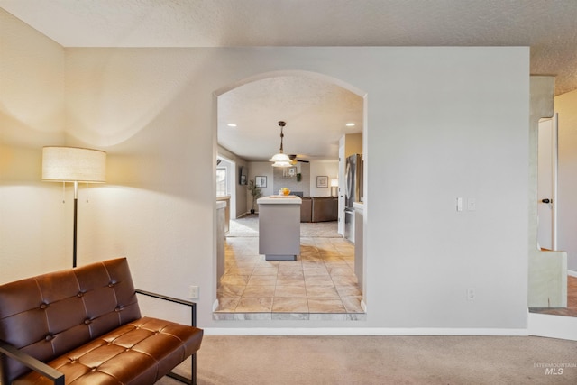 sitting room featuring arched walkways, recessed lighting, light carpet, a textured ceiling, and baseboards