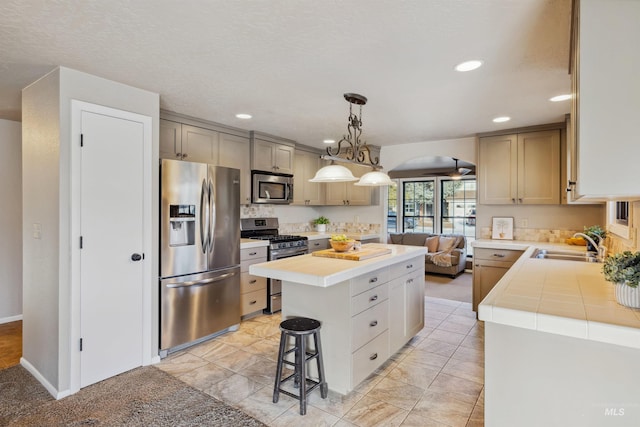 kitchen with arched walkways, a breakfast bar area, a sink, a kitchen island, and appliances with stainless steel finishes